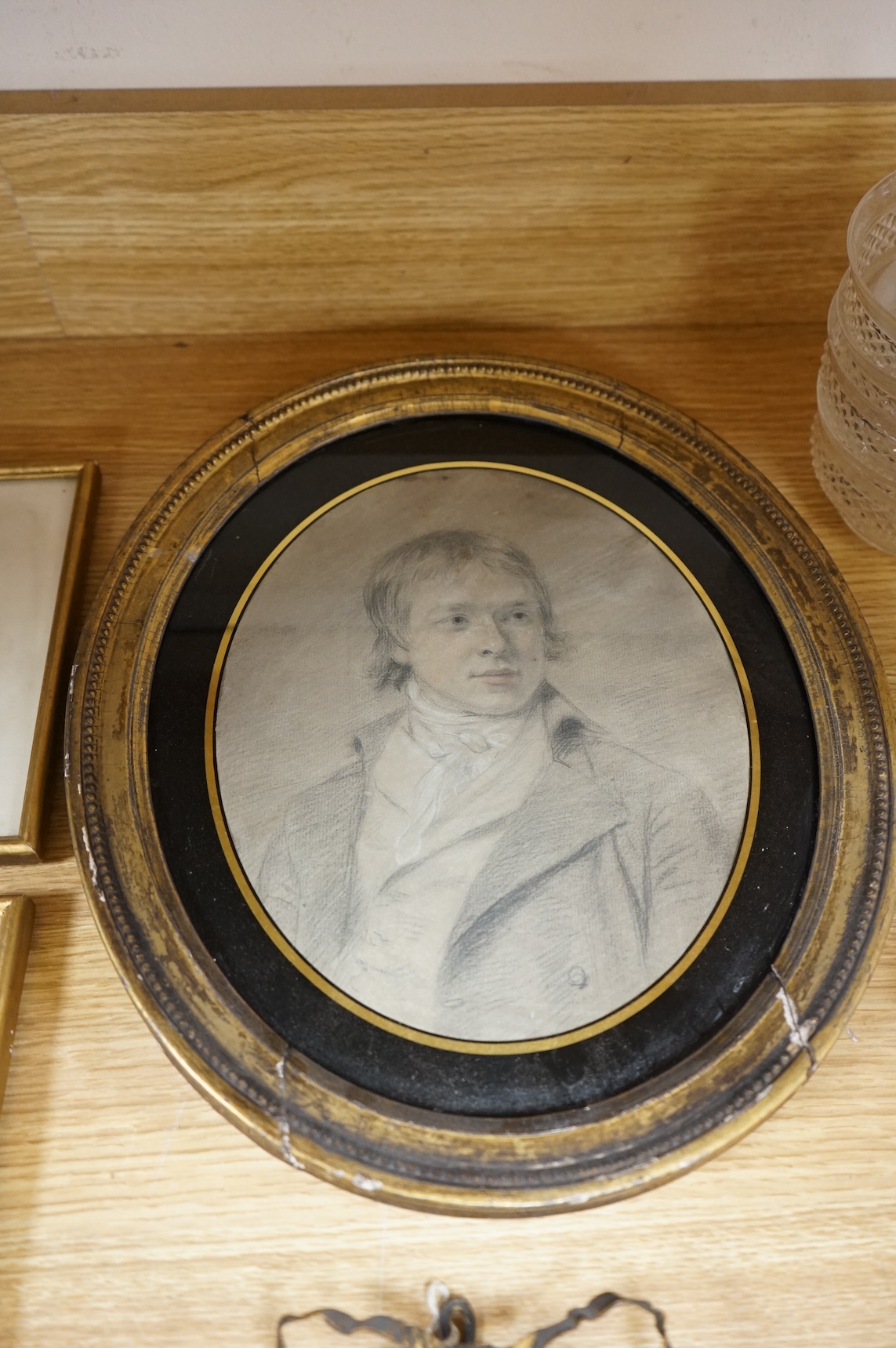 Four Regency and early Victorian portraits to include a pair of a lady and gentleman together with a carved wax bust of a lady wearing a bonnet, housed in an ebonised and gilt oval box frame, largest overall 38 x 32cm